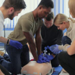 Closeup of students practicing CPR skills